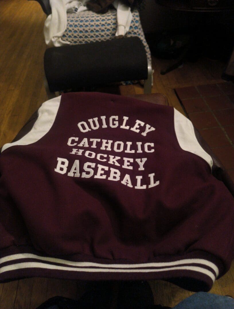 Maroon varsity jacket with 'Quigley Catholic Hockey Baseball' embroidered on the back.